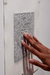 A visitor touching the embossed layer, making the print clearer.