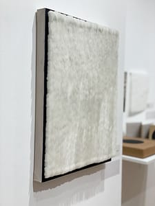 A side view of Scales, a piece with thousands of scale-shaped tabs adhered with oil paint on canvas creating a three-dimensional effect.
