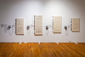A row of canvases with Braille painted on each and touch board technology wired to the left of each canvas.