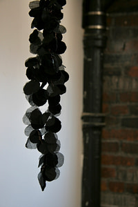 A close up of a petal like sculpture with velvet and mesh pieces tied together with thin metal wire.