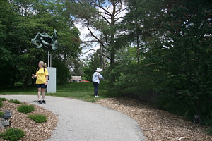 A participant touching leaves next to the CNIB Program Lead.