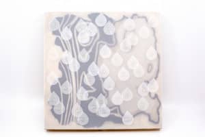 Image description: An artwork is veiled with a removable frosted Dura-lar film sleeve, blurring the painting behind. Small removeable teardrop shapes, also made of Dura-lar film, have Braille words scattered on the sleeve.